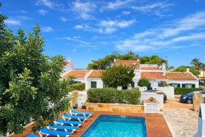 a swimming pool with lounge chairs and a house at Villa Sa Punta in Cala en Blanes