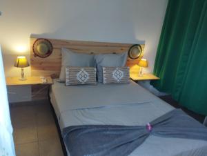 a bedroom with a bed with two tables and two lamps at Dauphin bleu in Saint-André +24 photos