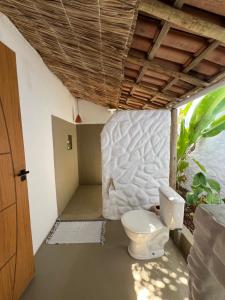 a bathroom with a toilet sitting under a ceiling at Pousada Quintal Caraíva in Caraíva
