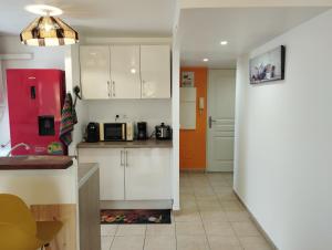 a kitchen with white cabinets and a red refrigerator at Dauphin bleu in Saint-André