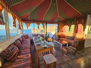 a living room with a couch and a table at Welle Surf House in Taghazout