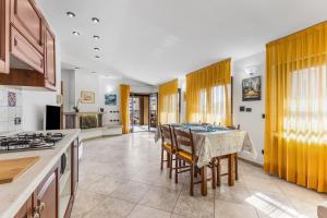 a kitchen with a table and chairs and a stove at Large apartment with terrace AC e WiFi in Sesto San Giovanni