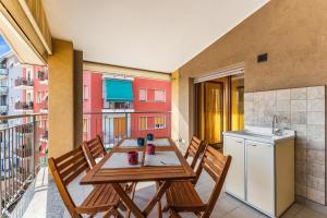 a balcony with a table and chairs and a kitchen at Large apartment with terrace AC e WiFi in Sesto San Giovanni