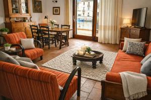 a living room with orange couches and a table at Bosa Exclusive Apartments "Bosa Apartments" in Bosa