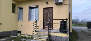 a house with stairs leading to a wooden door at Monolocale corte in Pavia