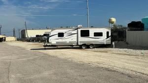 a white trailer parked on the side of a dirt road at Apollo Lodge and RV Park in Fairfield