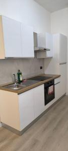 a kitchen with white cabinets and a sink at Monolocale corte in Pavia