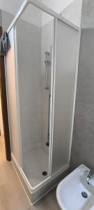 a shower with a glass door next to a sink at Monolocale corte in Pavia +8 photos