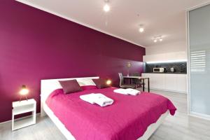 a purple bedroom with a large bed and a table at LC pokoje & apartamenty B52 in Szczecin