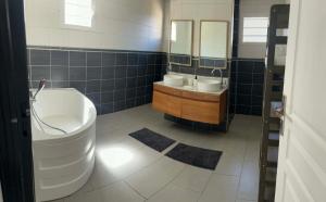 a bathroom with a tub and a toilet and a sink at Villa Valérie in Bras-Panon +5 photos