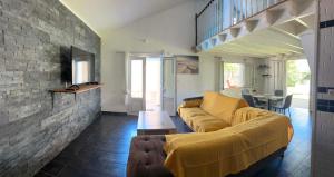 a living room with a yellow couch and a brick wall at Villa Valérie in Bras-Panon
