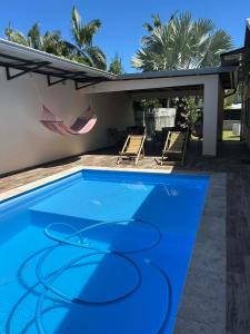 a blue swimming pool in front of a house at Villa Valérie in Bras-Panon