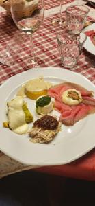 a white plate of food on a table at Rifugio Combe D'Imbert Vittoria in Champ Quartier