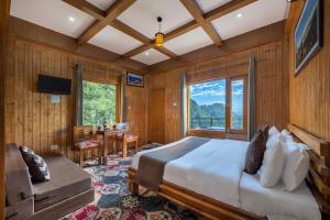 a bedroom with a large bed and a table at Gadegal Homestay Narkanda - Rooms & Pahadi Café in Shimla