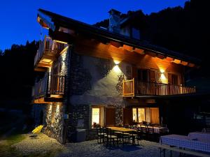 a building with a table and chairs in front of it at Rifugio Combe D'Imbert Vittoria in Champ Quartier