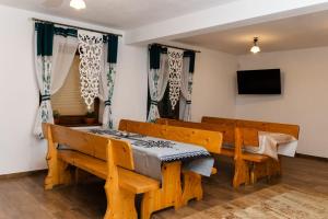 a room with two benches and a table and a tv at Pokoje u Jozka-Widok na Tatry in Groń