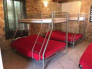 two bunk beds with red seats in a room at Gite d'étape le code bar in Saint-Julien-Labrousse