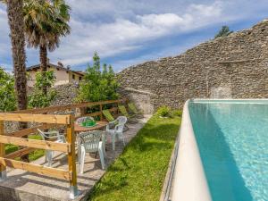 a patio with a table and chairs next to a swimming pool at Giardino del Convento in Domaso