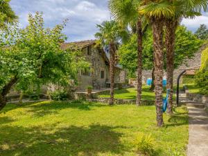 a house with palm trees in the yard at Giardino del Convento in Domaso