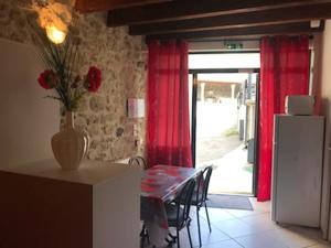 a kitchen with a table with a vase of flowers on it at Gite d'étape le code bar in Saint-Julien-Labrousse +2 photos