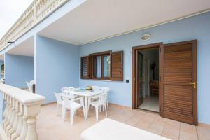a dining room with a white table and white chairs at Village Baia Turchese in Vieste