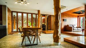 a living room with a table and a tree at Villa Amrita - Oceanfront Villa with Private Beach in Ko Phangan