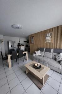 a living room with a couch and a table at Le Colibri in Fenouillet