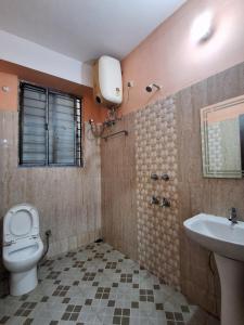 a bathroom with a toilet and a sink at Hotel New Castle in Guwahati