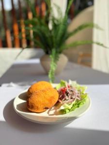 a plate with a sandwich and salad on a table at Regina Hotel in Lunahuaná +30 photos