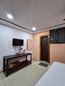 a room with a bed and a television and a table at Hotel New Castle in Guwahati