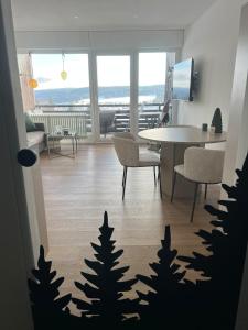 a living room with a table and chairs with trees on the floor at Black Forest Vista - Pool Sauna Tennis in Schonach