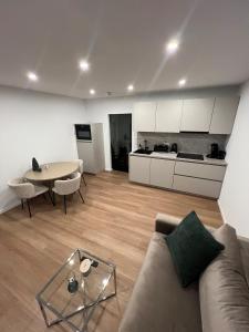 a living room with a couch and a table and a kitchen at Black Forest Vista - Pool Sauna Tennis in Schonach