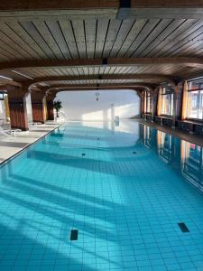 a large swimming pool with blue tiles on the floor at Black Forest Vista - Pool Sauna Tennis in Schonach