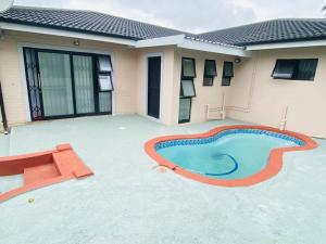 a swimming pool in front of a house at Slee Guest House in Howick