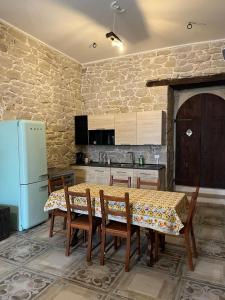 a kitchen with a table with chairs and a refrigerator at Casa vacanze La Fenice 2 in Pietranico +1 photo