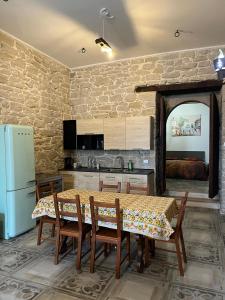 a kitchen with a table with chairs and a refrigerator at Casa vacanze La Fenice 2 in Pietranico