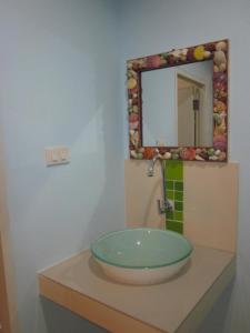 a bathroom with a sink and a mirror on a counter at Toonja Kohlarn in Ko Larn