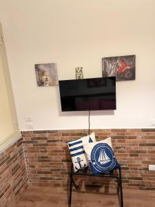 a living room with a tv on a brick wall at Come A To Casa in Aspra