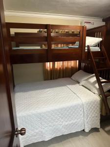 two bunk beds in a room with a white bed at Elevate View Penthouse in Santo Domingo