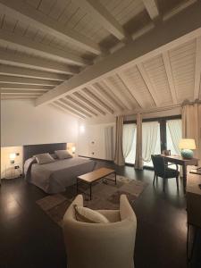 a bedroom with a bed and a table and chairs at Maison Jardin in Ostiano