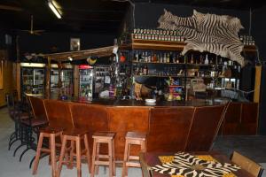a bar with wooden bar stools in a restaurant at Kenhardt Hotel in Kenhardt