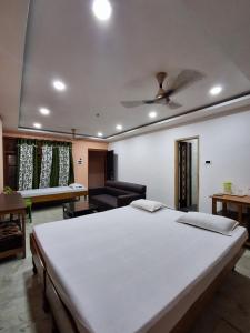 a bedroom with a large white bed and a couch at Hotel New Castle in Guwahati