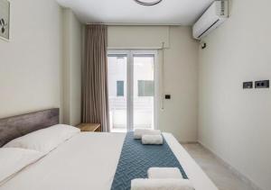 a bedroom with a large white bed with two chairs at Relax Seafront Apartment by PS in Golem