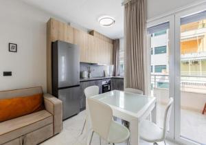 a kitchen with a white table and chairs in a room at Relax Seafront Apartment by PS in Golem