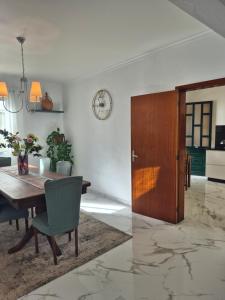 a dining room with a table and a wooden door at Villa Vista Norte in Porto Moniz