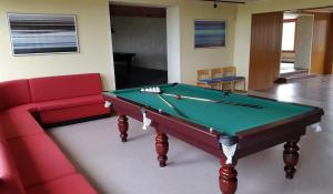 a room with a pool table and a red couch at Nord Fish Apartments in Skarstein +26 photos