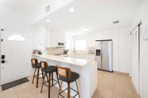 a kitchen with white cabinets and bar stools at Northern Lights #6 Condo in Old Man Bay