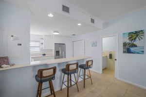 a kitchen with three bar stools and a counter at Northern Lights #6 Condo in Old Man Bay