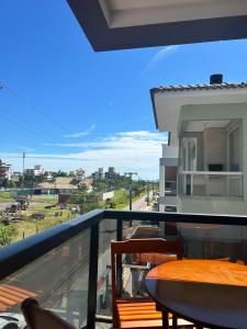 a balcony with a table and chairs and a view at Apê Ásia in Governador Celso Ramos