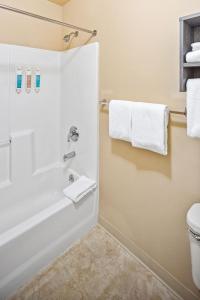 a bathroom with a shower with white towels at Aviator Suites Hotel Juneau Airport by Aspen Hotels in Juneau +27 photos